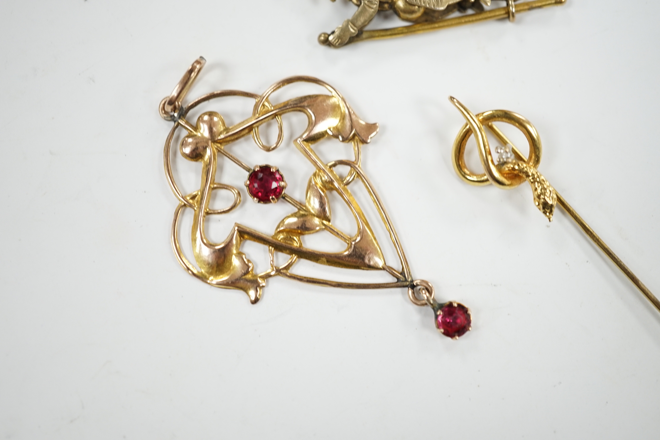 An Art Nouveau yellow metal and two stone gem set drop pendant, 53mm, an articulated Mr Punch charm and a modern 9ct gold and diamond chip set serpent stick pin.
